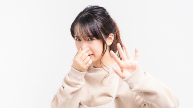 エアコンの臭いに困っている女性の写真